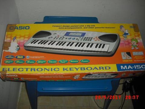 Bello piano teclado casio en su caja con su cargador de corriente